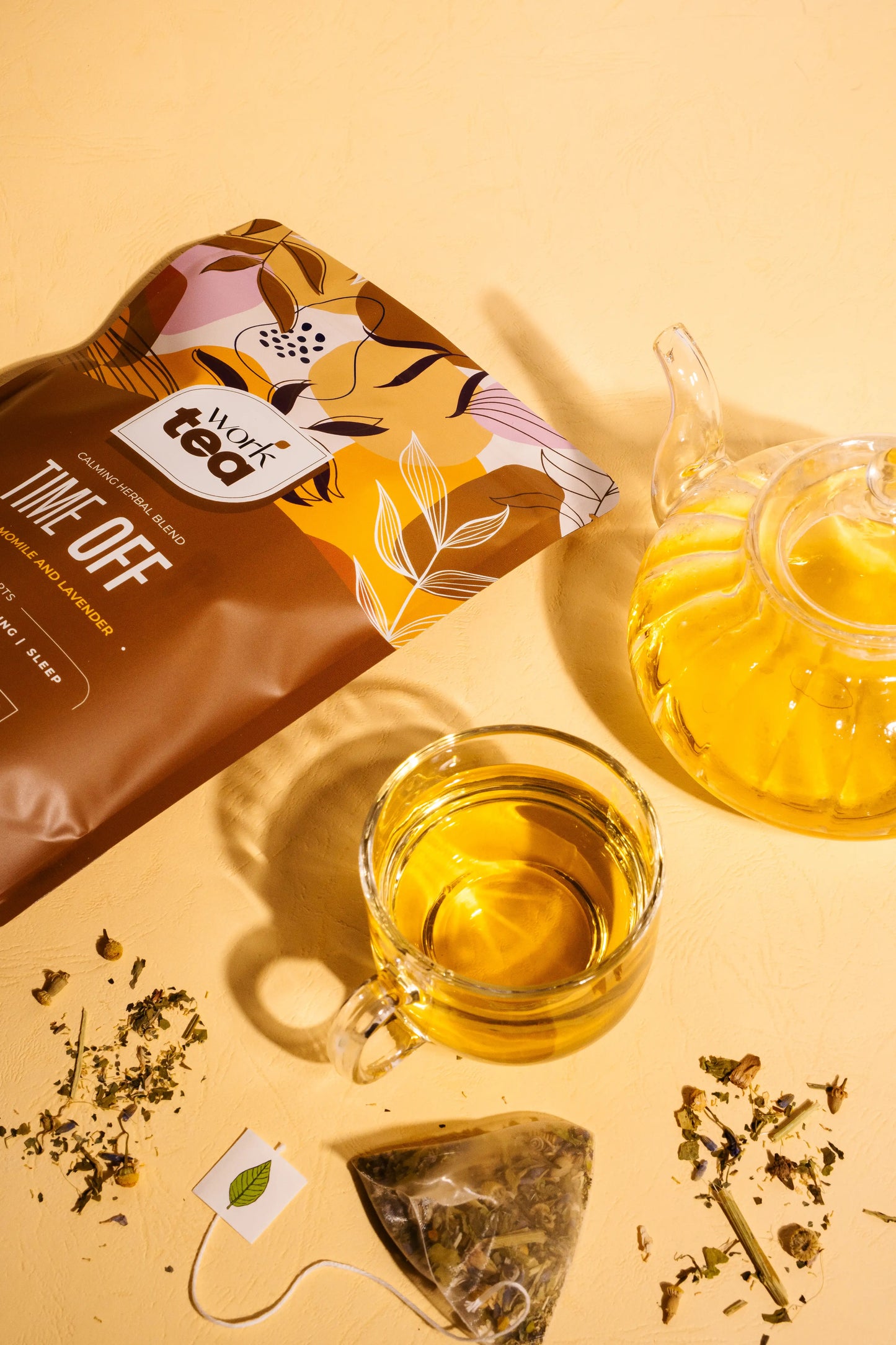 Tea packaging with a cup of tea, teapot, and tea leaves on a yellow background