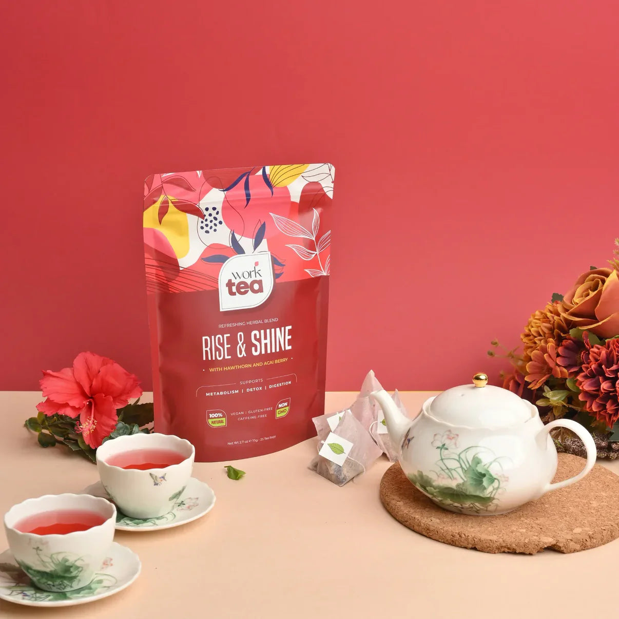 Tea packaging labeled 'Rise & Shine' with tea cups, teapot, and flowers on a pink background