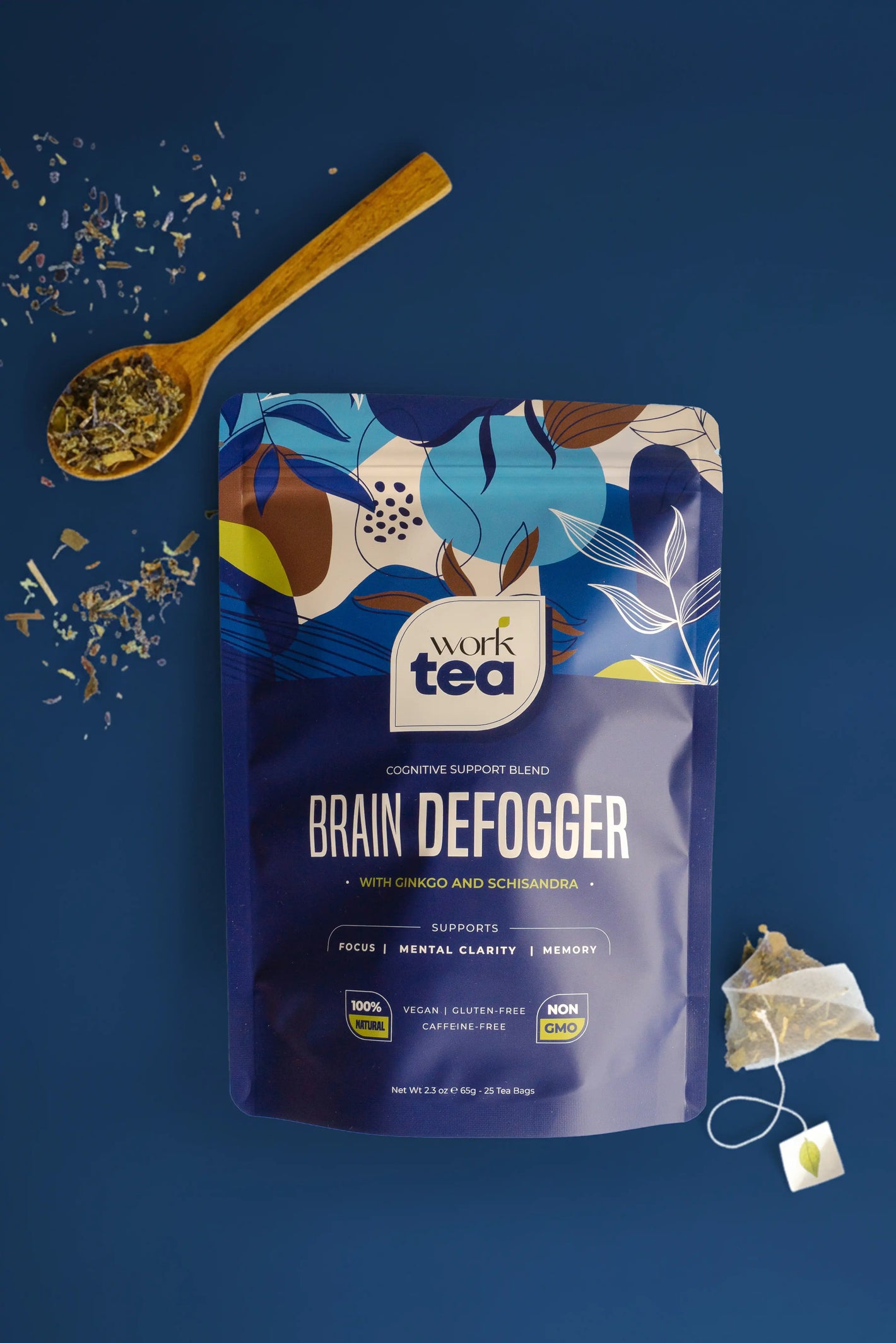 Work Tea Brain Defogger package with a wooden spoon and tea bag on a blue background
