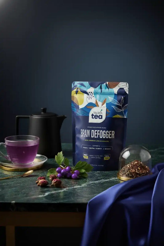 Tea package labeled 'Grain Defogger' on a table with a cup of tea and decorative elements.