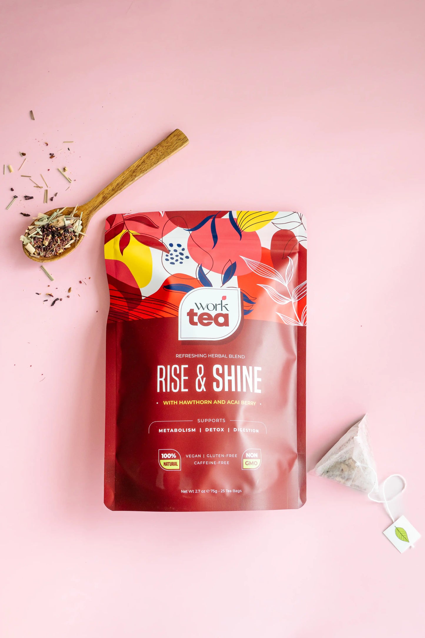 Work Tea 'Rise & Shine' package on a pink background with a spoon and tea leaves.