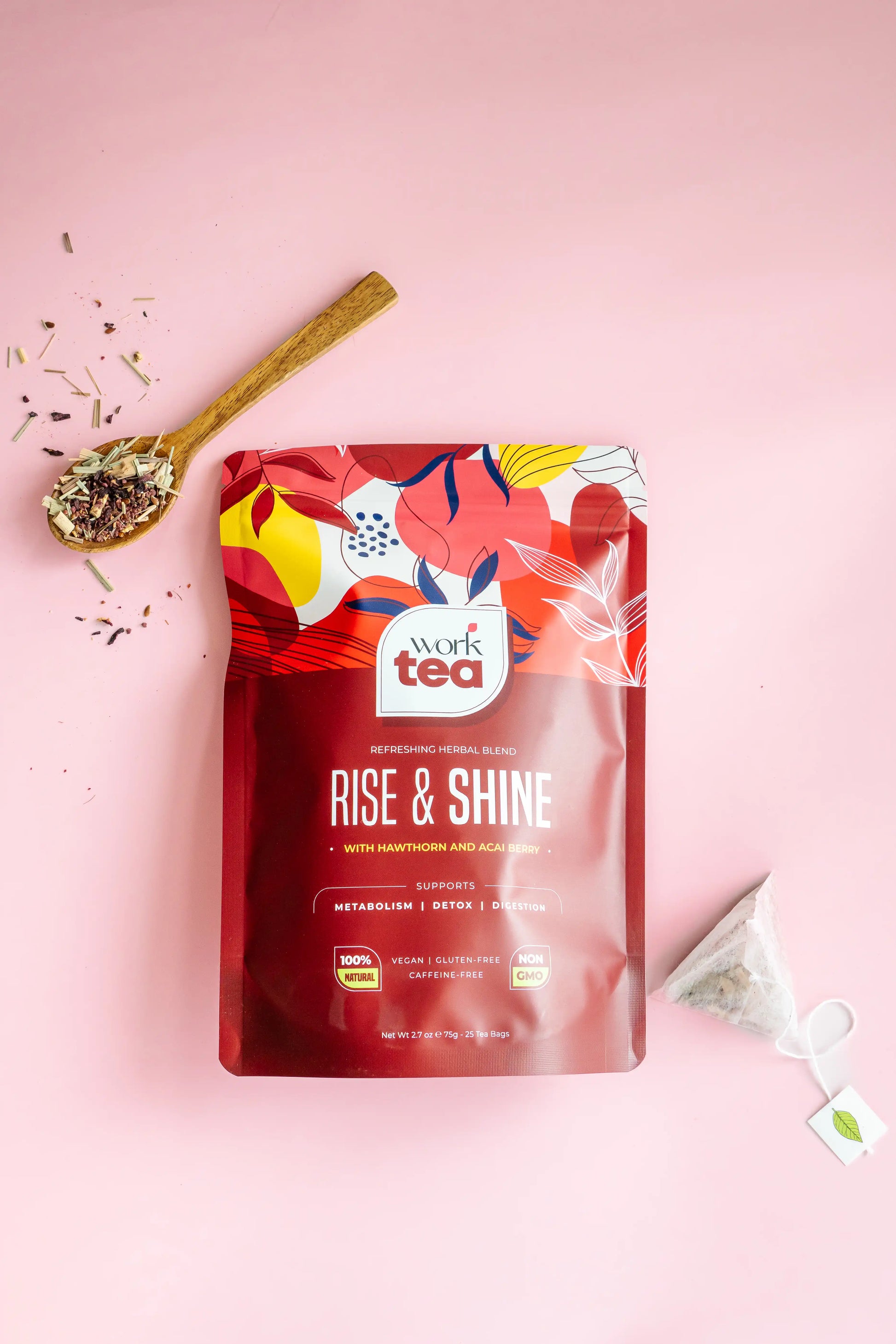 Work Tea 'Rise & Shine' package on a pink background with a spoon and tea leaves.